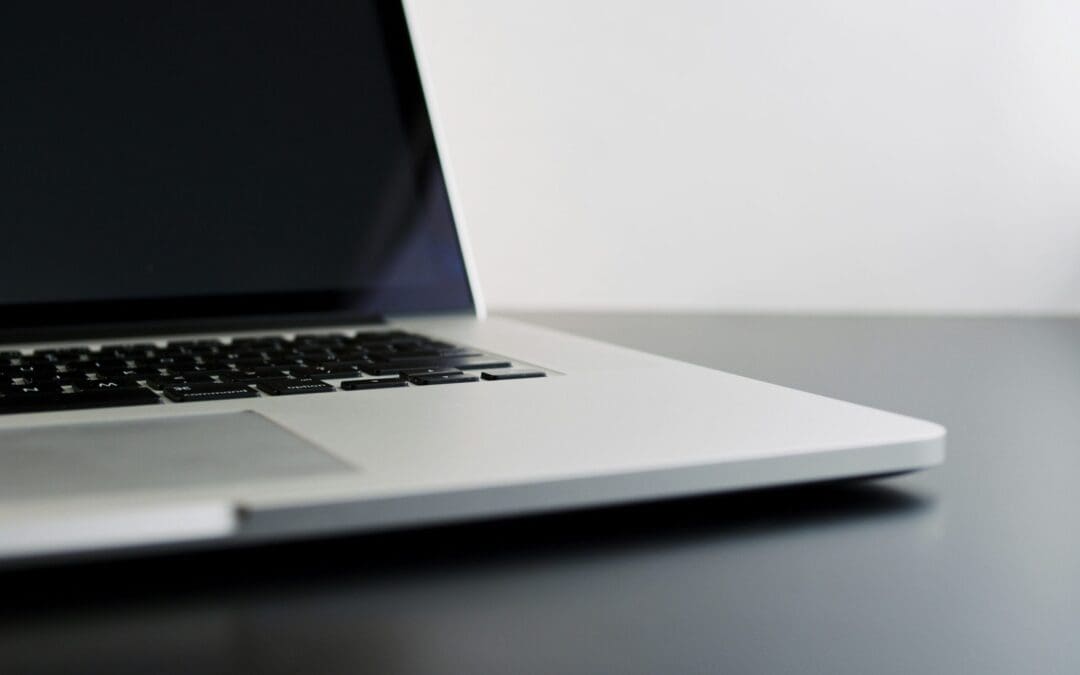 silver laptop computer on black table